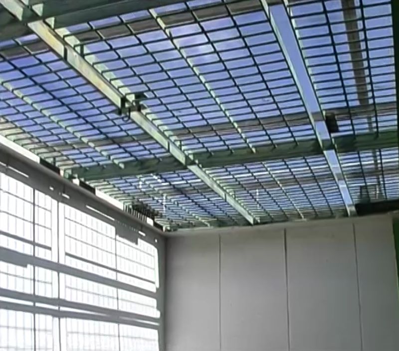 Blue sky beyond the wired bars of an enclosed corner