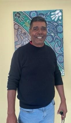 Man standing in front of indigenous artwork