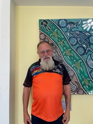 Man standing in front of indigenous artwork